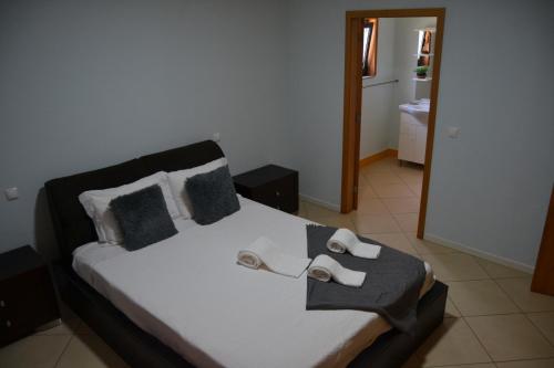 a bedroom with a bed with white sheets and pillows at Casa do Vale - Casa da Montanha - Gerês in Geres