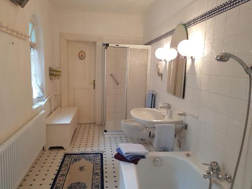 ein weißes Badezimmer mit einer Badewanne und einem Waschbecken in der Unterkunft Ferienwohnung Schloss Schrattenthal in Schrattenthal