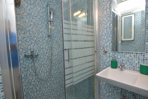 bagno piastrellato blu con doccia e lavandino di Athens Stylish studio in front of Syntagma metro stop for 2 ad Atene