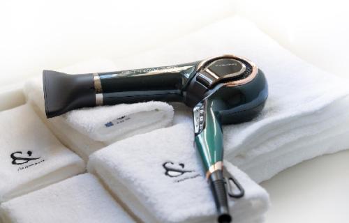 a hair dryer sitting on top of towels at ritomaru villa @ hatsuyama iki in Iki