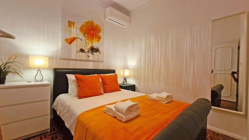 a bedroom with a bed with an orange blanket at Casa do Carmo - Fuzeta in Fuzeta