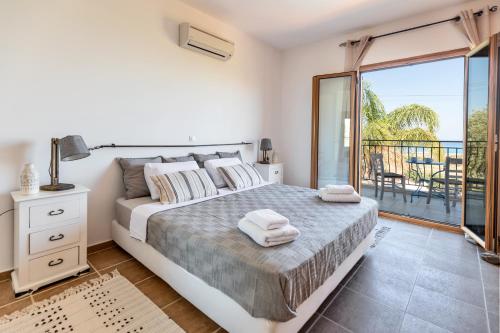a bedroom with a bed and a balcony at Villa AmberBlue Kalathos in Kalathos