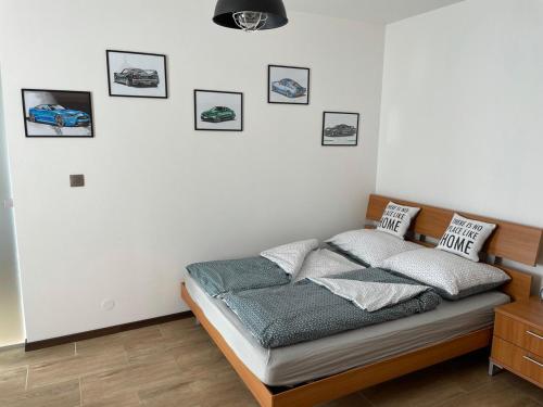 a bedroom with a bed with pictures on the wall at Newly renovated 2 rooms apartment downtown Nitra in Nitra