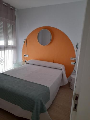 1 dormitorio con 1 cama grande y cabecero naranja en Hostal Casandra - antiguo Hostal Los Valencianos en Conil de la Frontera