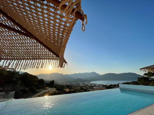 a swimming pool with a balcony overlooking the ocean at Renata's Villas in Karpathos