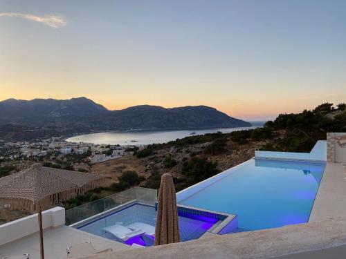 a beach with a view of the ocean and mountains at Renata's Villas in Karpathos