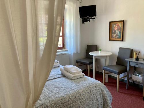 a room with a bed and two chairs and a window at Penzion Moravia - free parking in the city center in Mikulov