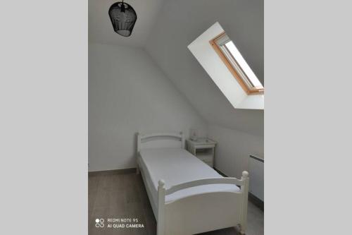 a white bed in a room with a window at Au gîte d'oye - Gîte neuf proche de la plage in Oye-Plage