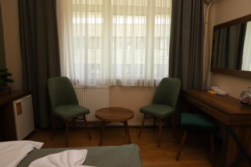 a hotel room with two chairs and a desk and a mirror at Buldum Otel in Ankara