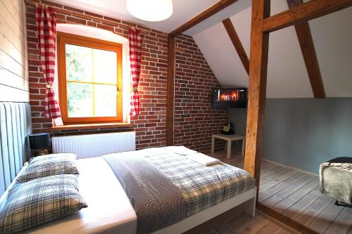 una camera da letto con un letto e un muro di mattoni di Guesthouse BORSZÓWKA by the creek exclusive, with access to a pool, sauna, and hot tub a Szklarska Poręba