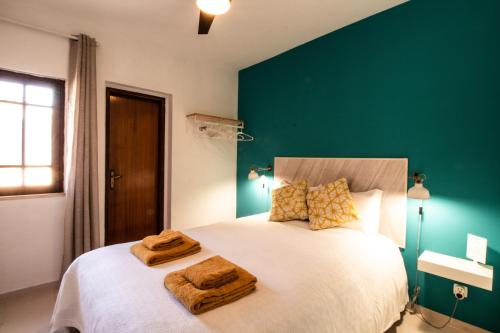 a bedroom with a large white bed with a green wall at Quinta do Paraíso - Bed&Shower in Albufeira