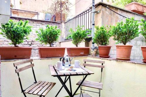 un tavolo e due sedie su un patio con piante di Cedro Home a Roma
