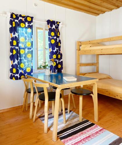 a dining room with a table and chairs and a bunk bed at Haikolan talo in Lipinlahti