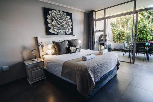 a bedroom with a bed with a table and a window at 9 Kyalanga Beach in Durban