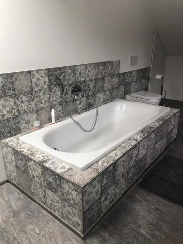 a large bath tub in a bathroom with a toilet at fermette in Lontzen