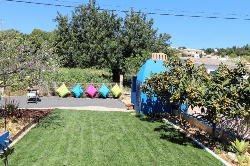 a yard with a blue fence with kites in the background at Quinta do Silvestre in Albufeira