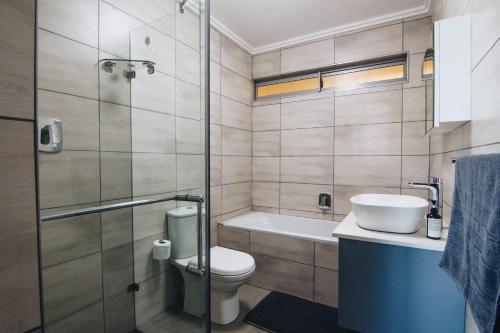 a bathroom with a toilet and a sink and a shower at 9 Kyalanga Beach in Durban