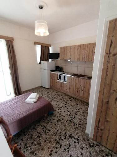 a bedroom with a bed and a refrigerator and a kitchen at Villa Teo in Kalamata