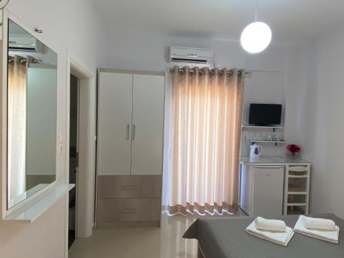 Habitación con cama y espejo. en Villa Erdeti Studio & Apartment, en Sarandë