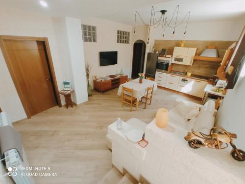 ein Wohnzimmer mit einem weißen Sofa und einem Tisch in der Unterkunft La ramasola & il datterino in Pezze di Greco