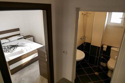 a small bathroom with a bed and a toilet at Tophill Apartments in Borsh