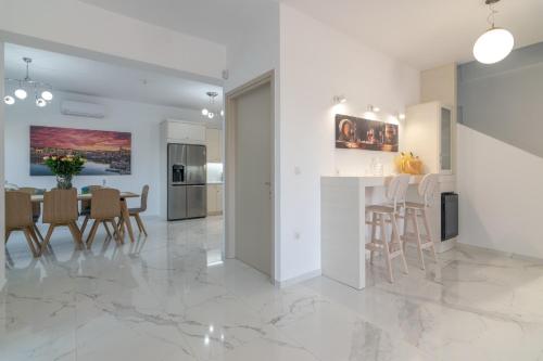 a white kitchen and dining room with a table and chairs at Manuel's Dream in Ádhele