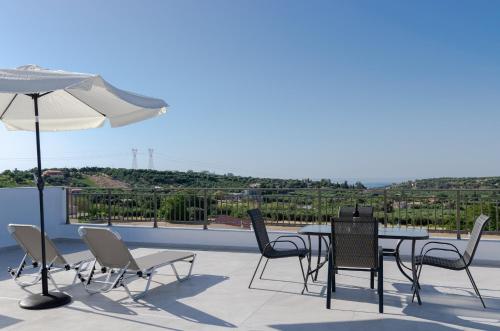 a patio with a table and chairs and an umbrella at Manuel's Dream in Ádhele
