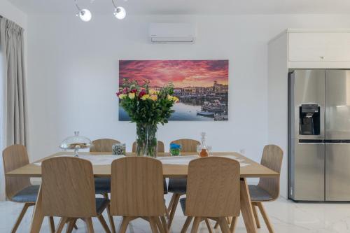 a dining room table with chairs and a vase of flowers at Manuel's Dream in Ádhele