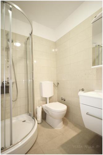 a bathroom with a toilet and a shower and a sink at Apartments Nika in Primošten