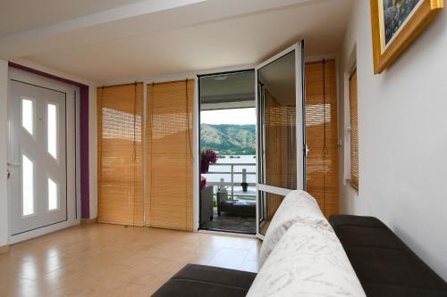 a living room with a couch and a glass door at Vila Kozokic in Kladovo