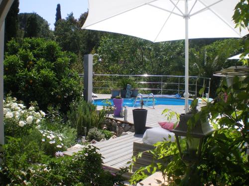 um pátio com um guarda-sol e uma piscina em Villa Sanssoucis Les Issambres em Les Issambres