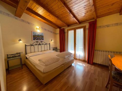 a bedroom with a bed and a wooden ceiling at Hotel Rabay in Brenzone sul Garda