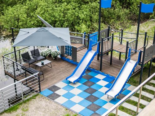 a playground with a slide and an umbrella at Cobalt Apartments in Mikołajki