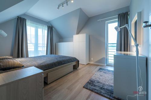 a bedroom with a bed and a large window at Rydzewo domek w zabudowie szeregowej nad jeziorem in Rydzewo