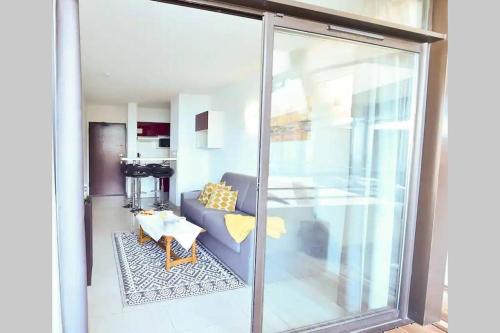 a living room with a couch and a table at CosySeaside Corsica Ajaccio Piscine Terrasse Mer in Ajaccio