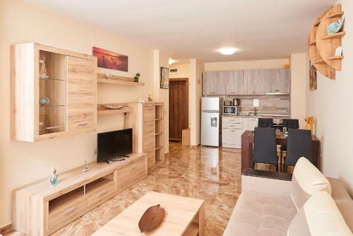 a living room with a couch and a kitchen at Апартаменти "Лазур" в сърцето на Поморие in Pomorie