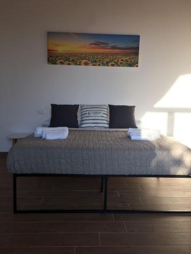 a bed in a bedroom with a painting on the wall at Terra di Suli in Custonaci