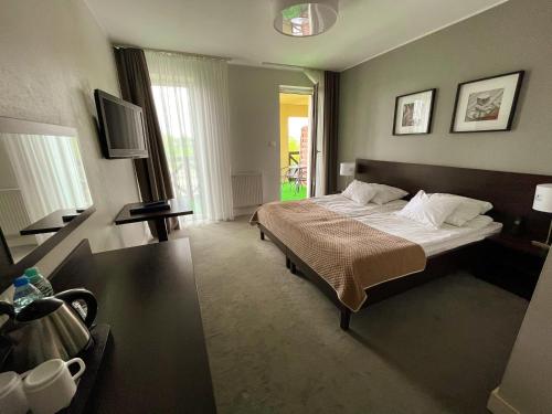 a hotel room with a bed and a window at Hotel Santa Monica in Mikołajki