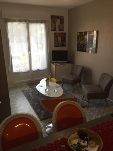 un salon avec un canapé, une table et des chaises dans l'établissement logement entier -studio parfait état a La Baule-proche plages, à La Baule