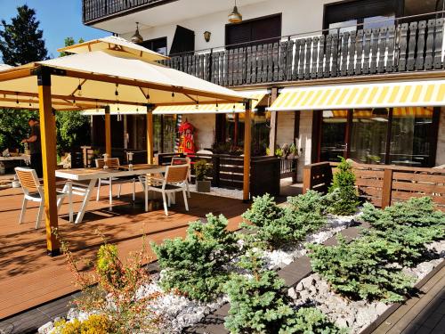 un patio con mesa, sillas y sombrilla en Hotel Rössle en Dobel