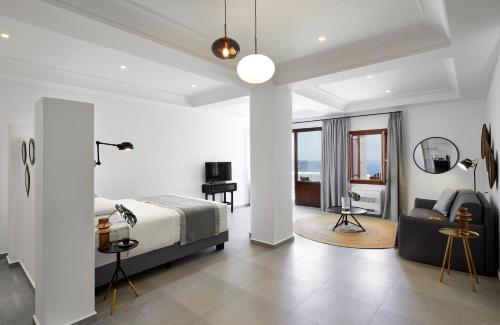 a bedroom with a bed and a desk and a couch at Petit Palace Suites in Fira