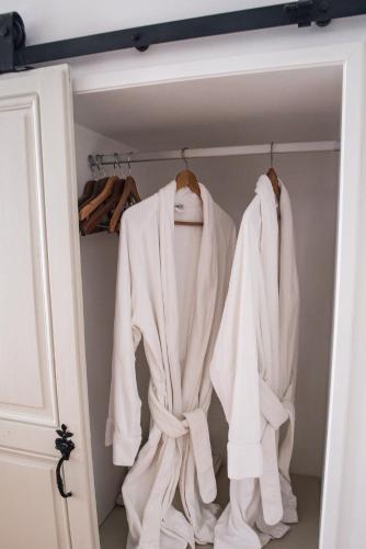 a closet with white clothes hanging in it at LE BAS CHITRAY in Ménil