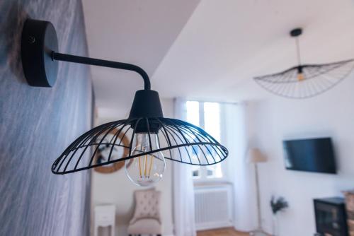 a black lamp hanging from a wall in a room at LE BAS CHITRAY in Ménil
