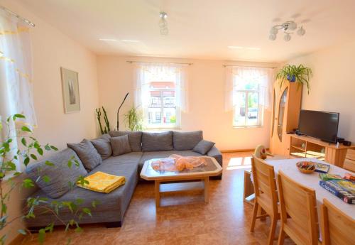 ein Wohnzimmer mit einem Sofa und einem Tisch in der Unterkunft Cosis Ferienwohnung in Hohnstein