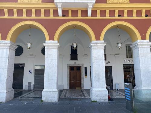 a building with three columns and a brown door at Samourai Massena Lodge -1 min from the sea in Nice