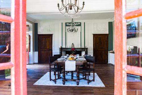 a dining room with a table and chairs and a chandelier at LE BAS CHITRAY in Ménil