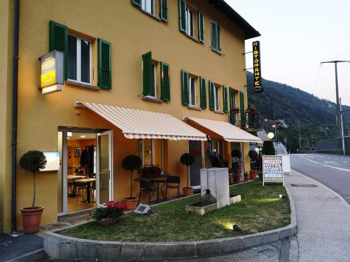 um edifício ao lado de uma rua com um restaurante em Hotel Elvezia em Lavorgo