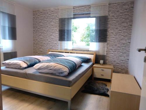 1 dormitorio con 1 cama con pared de ladrillo en Ferienwohnung Kürmreuth en Königstein in der Oberpfalz