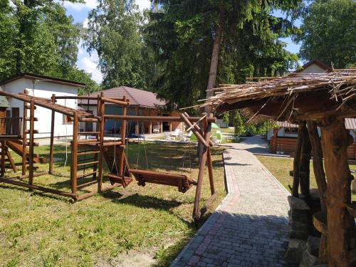 a wooden structure sitting on the grass near a building at Svitiaz Griada in Szack