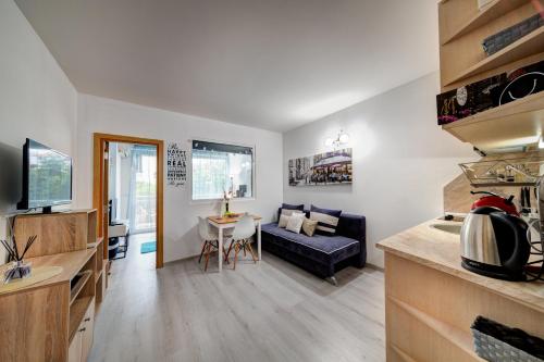 a kitchen and living room with a couch and a table at Decor in Atlantis Resort&SPA by RV Apartments in Burgas City